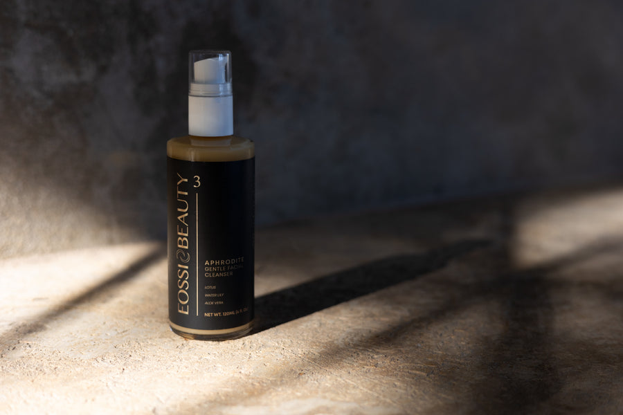 Eossi Beauty Aphrodite Cleanser pump bottle on stone in warm sunlight